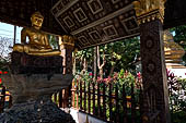 Wat Xieng Thong temple in Luang Prabang, Laos. The small pavilion with a seated Buddha statue. 